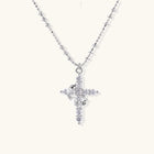 White gold-plated cross pendant adorned with sparkling zirconia stones and crescent moon accent on ball chain