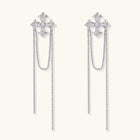 White gold plated baroque cross stud earrings with long cascading zirconia chains on cream background