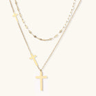 Three-layered gold necklace set with graduated cross pendants in mixed chain styles on white background.