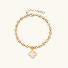 18K gold-plated oval bead bracelet with a four-leaf clover charm in mother-of-pearl or black enamel, adjustable lobster clasp, on white background.