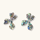 Pair of oversized four-petal flower stud earrings with iridescent teal and blush shell mosaic on silver-tone petals.